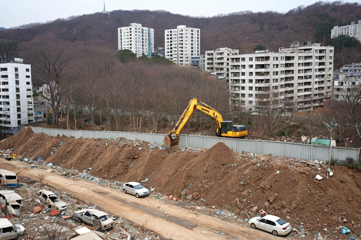 서울 봉천동 주거지역의 철거 현장 주변에 설치된 소음 방지용 흡음막이 펼쳐진 모습. 주변 건물과 나무가 보이며, 철거 작업 중인 건물의 외벽에 흙먼지가 약간 남아 있는 모습.